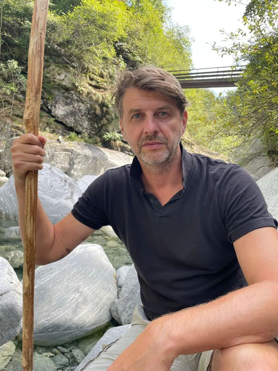 Portret van Steve Verbist aan een rivier in de bergen